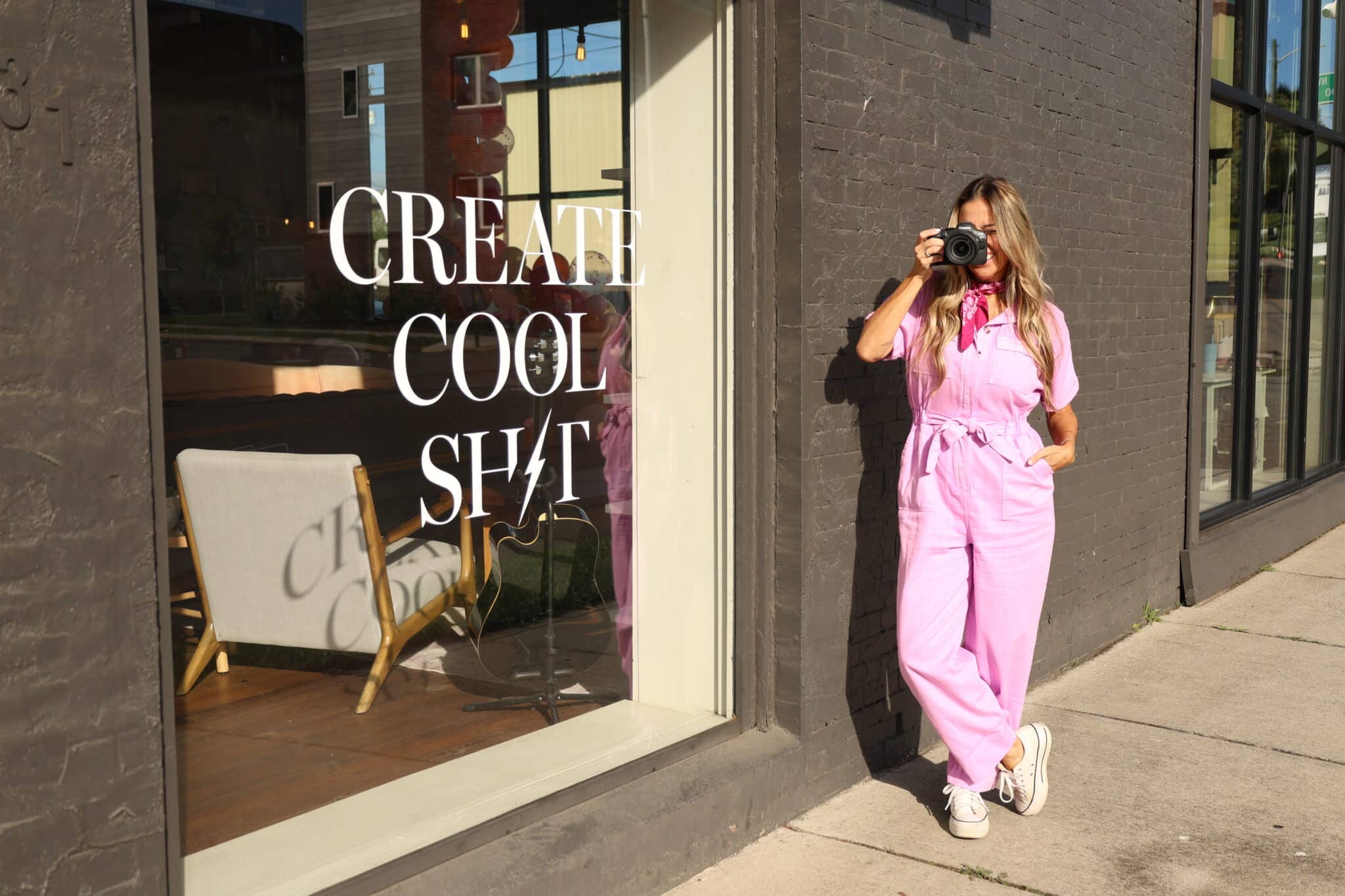 South Made Marketing photographer holding camera outside the Create Cool Shit window in Knoxville Tennessee